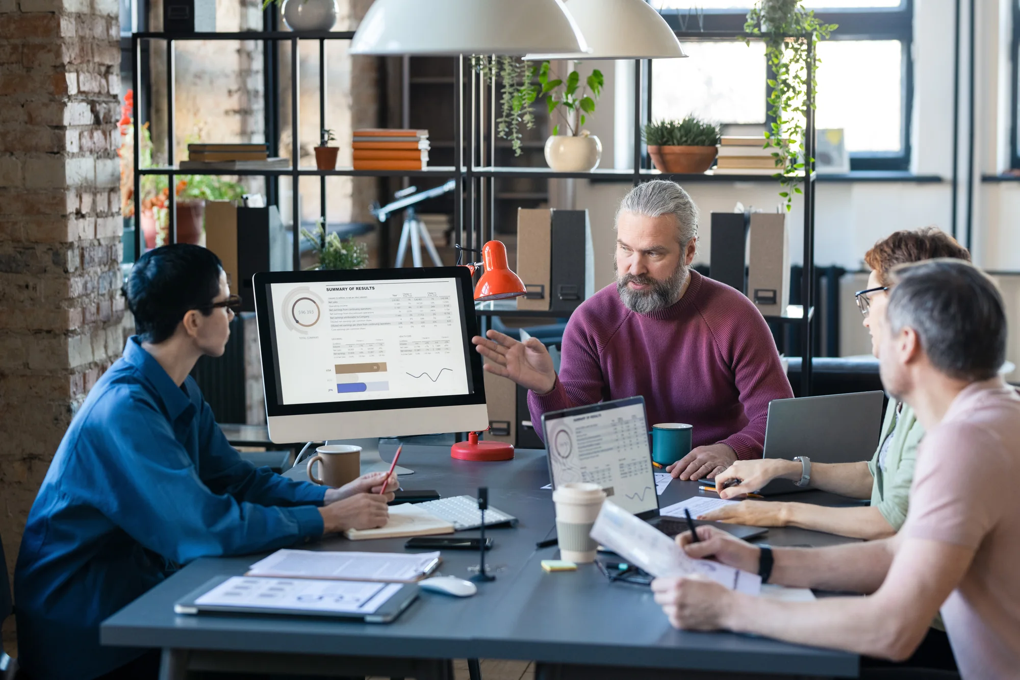 Canadian small business team reviewing plans around a table