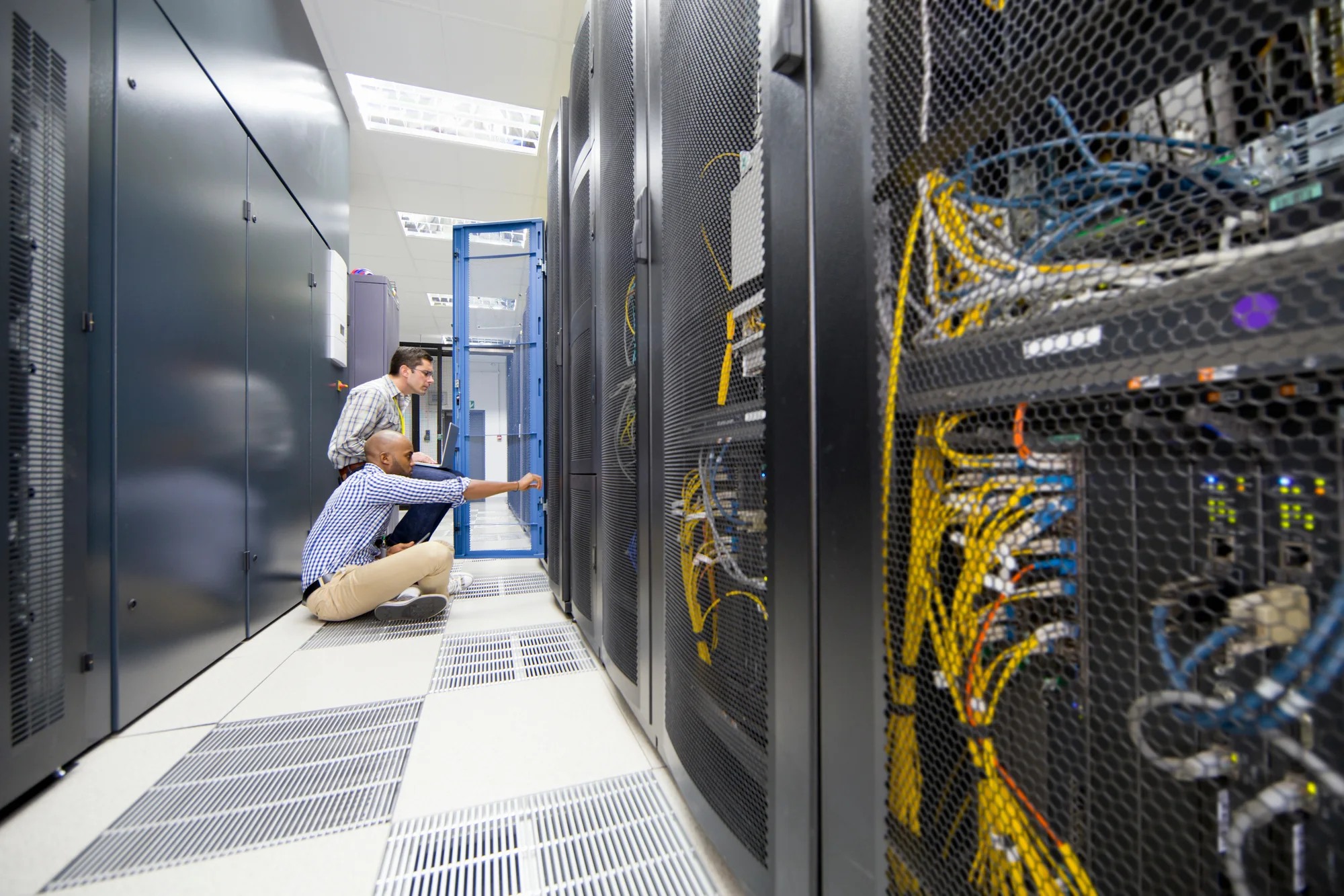 Technology professionals inspecting server equipment in a data centre