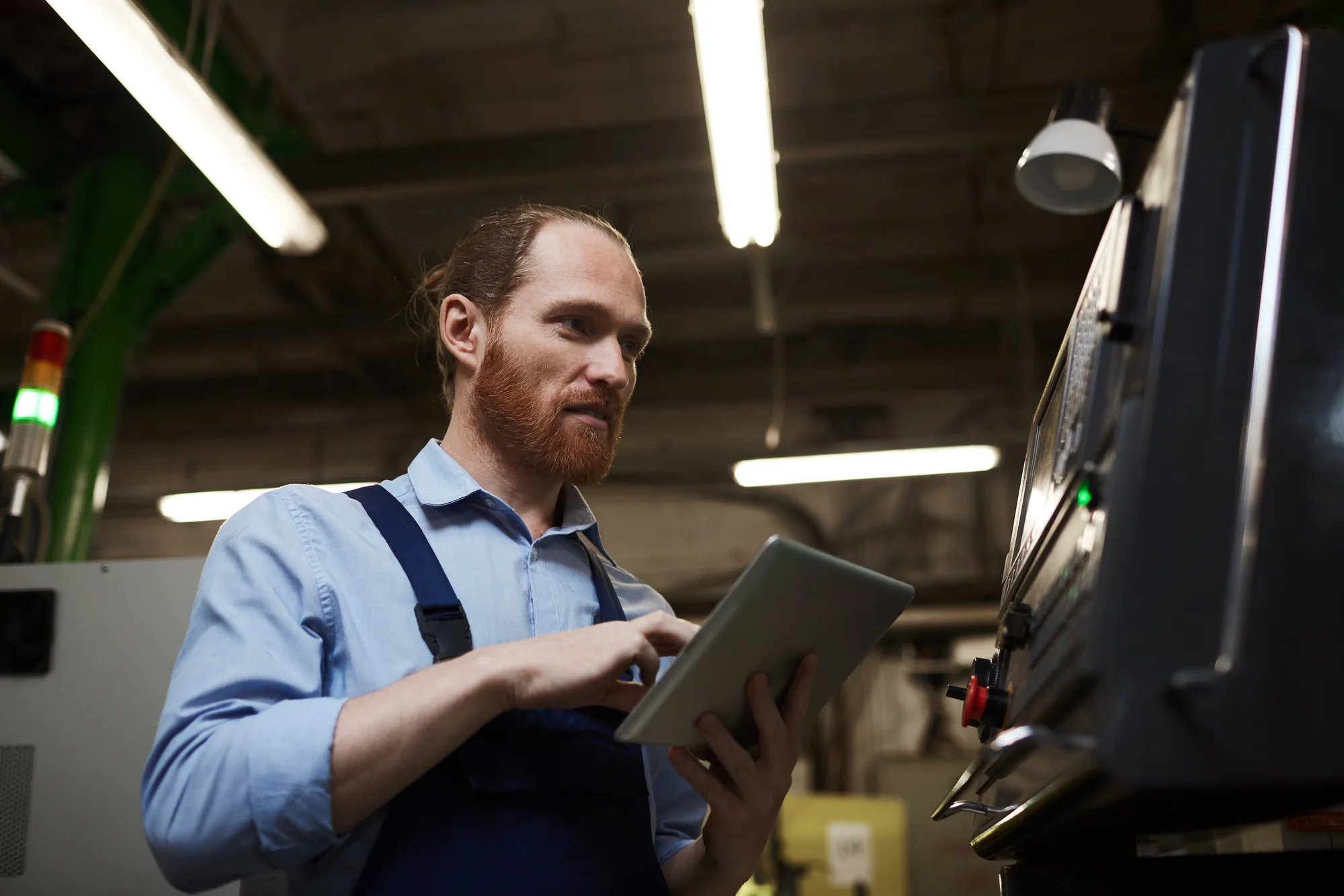 Business owner evaluating newly delivered industrial equipment with a tablet